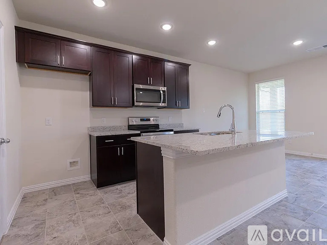 A kitchen with dark brown cabinets and a white countertop.
