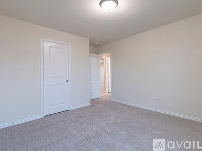 A spacious room with a carpeted floor and two doors.