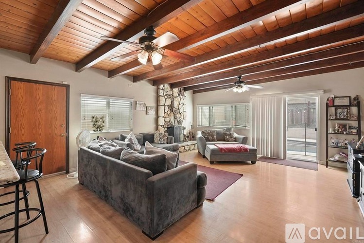 A living room with a grey couch and a wooden ceiling.