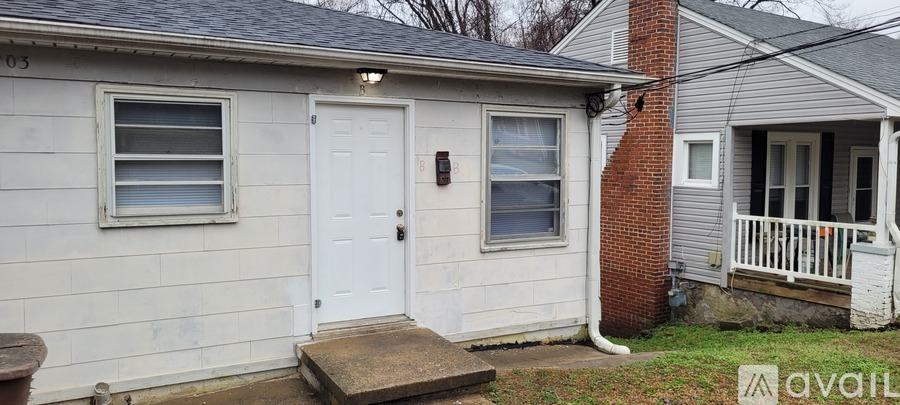 A small house with a white door and a small porch.