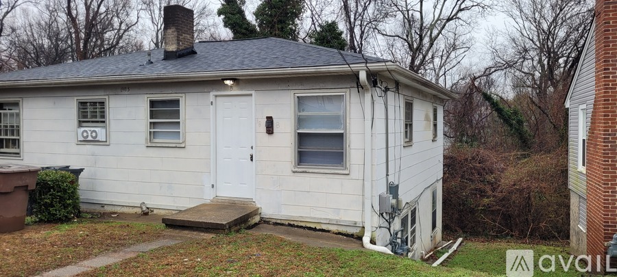 A small white house with a brown door and a window with a white frame.