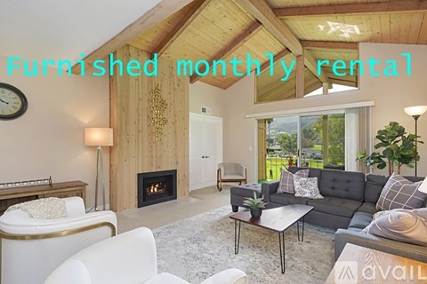 A living room with a fireplace and furniture for rent.