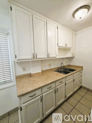 A kitchen with white cabinets and a sink.