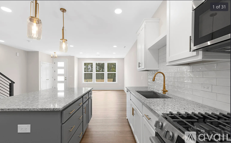 A modern kitchen with a stove top oven and a microwave above the counter.