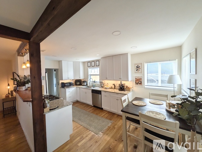A kitchen with a wooden floor and white walls.