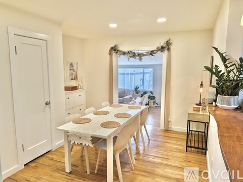 A dining room with a table set for six people.