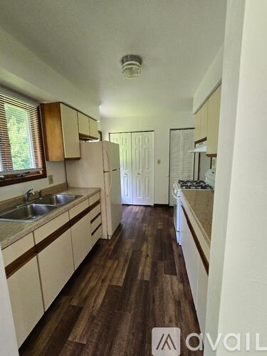 A kitchen with wooden floors and white cabinets.