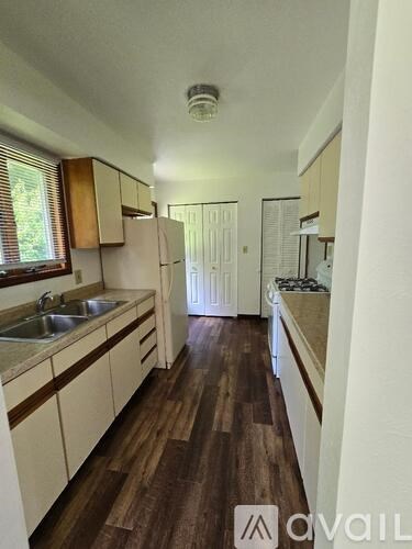 A kitchen with wooden floors and white cabinets.