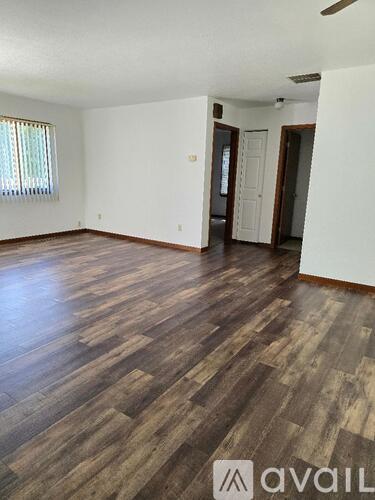 A room with wooden flooring and white walls.