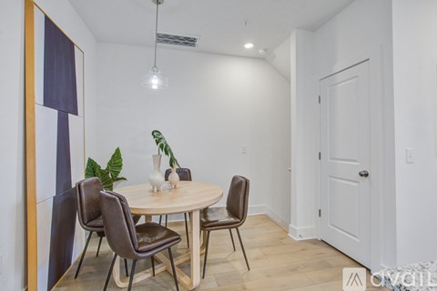 A dining room with a round table and chairs.