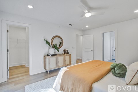 A bedroom with a bed, a wreath, and a cabinet.