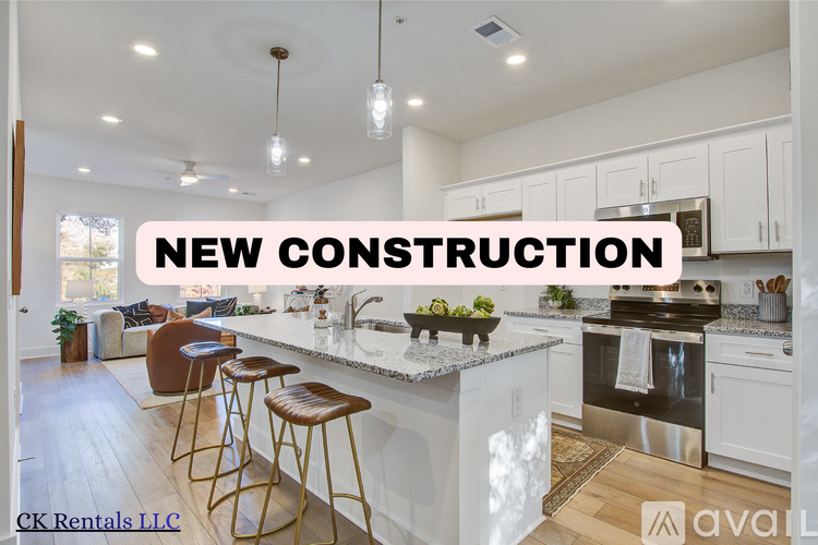 A kitchen with a bar and stools in a new construction.