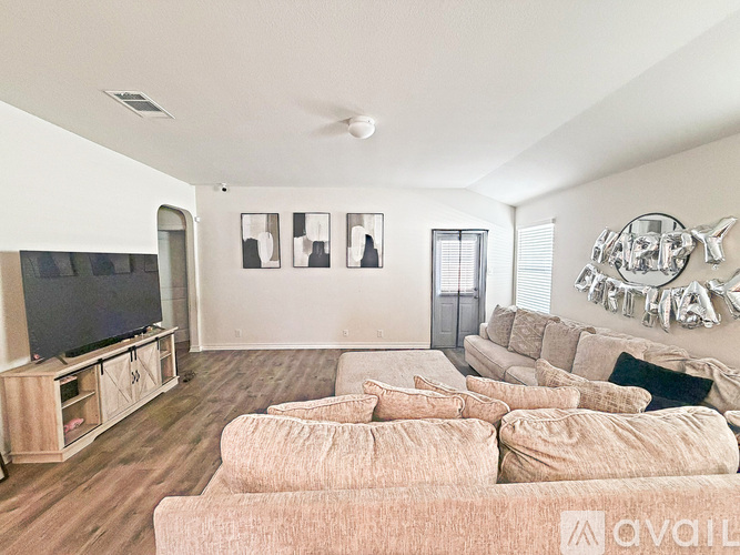 A living room with a large couch and a television.