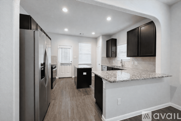 A kitchen with a refrigerator, cabinets, and a countertop.