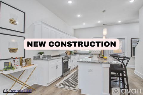 A modern kitchen with white cabinets and a black and white checkered rug.