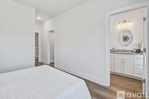 A bedroom with a large bed and a vanity with a mirror.