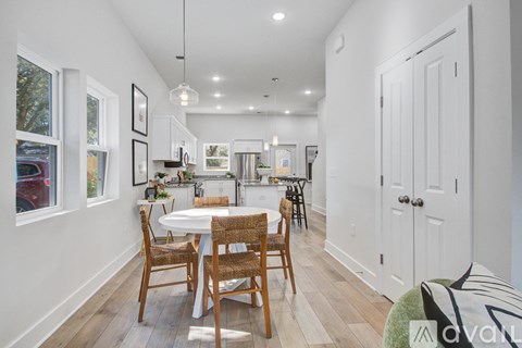 A dining room with a white table and chairs.