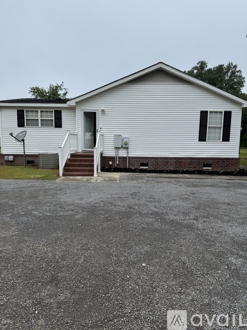 A mobile home with a white exterior and a grey roof.