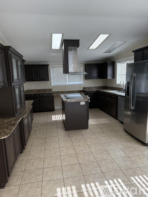 A kitchen with black cabinets and stainless steel appliances.