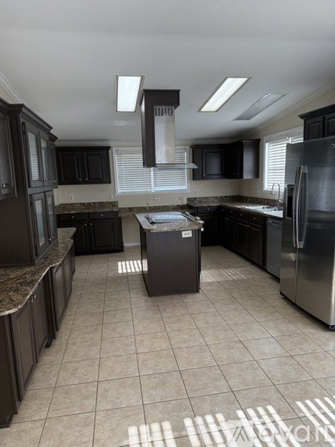A kitchen with black cabinets and stainless steel appliances.