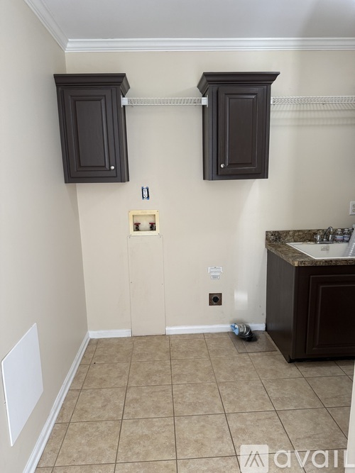 A bathroom with a sink and two cabinets.