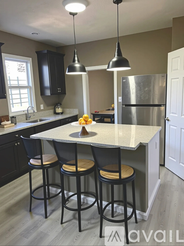 A kitchen with a bar area and a refrigerator.
