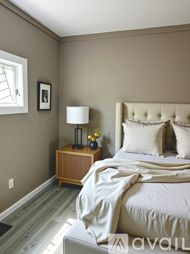 A bedroom with a large bed and a wooden nightstand.