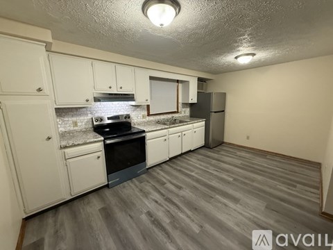 A kitchen with white cabinets and a black stove top oven.
