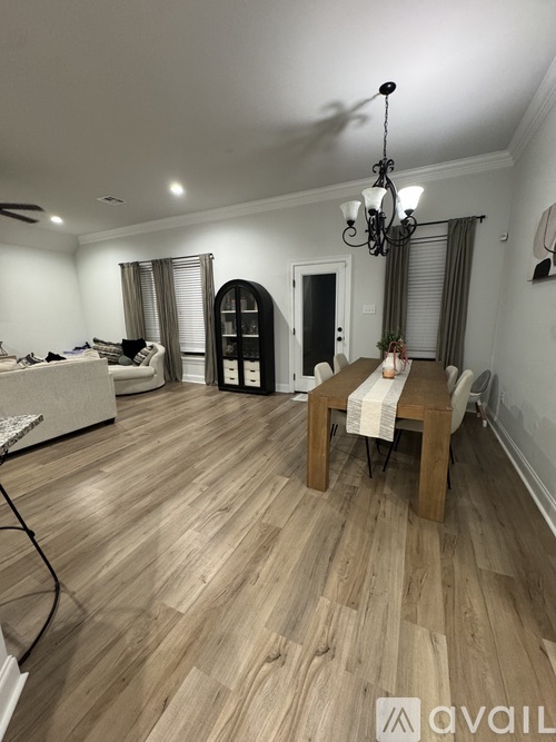A room with wooden flooring and a chandelier.