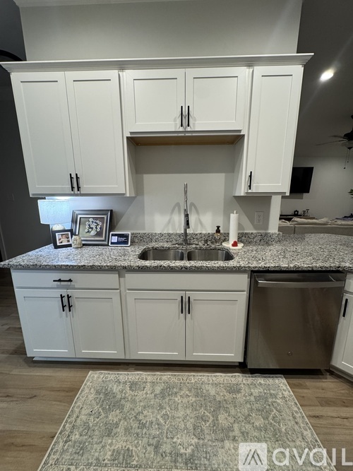 A kitchen with white cabinets and a granite countertop.