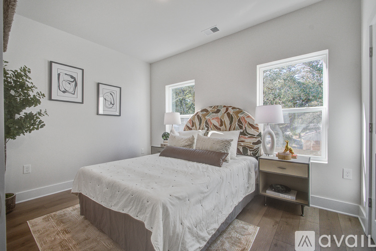 A bedroom with a bed, nightstand, and two framed pictures on the wall.