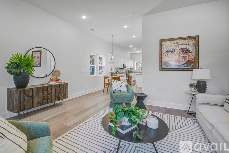 A living room with a green armchair, a wooden cabinet, and a painting on the wall.