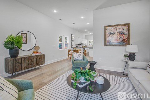 A living room with a green armchair, a wooden cabinet, and a painting on the wall.