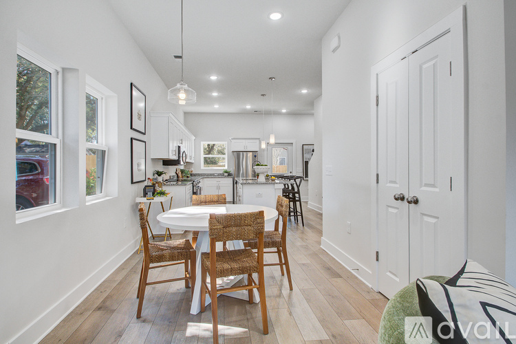 A dining room with a white table and chairs.