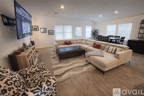A living room with a large couch and a television mounted on the wall.