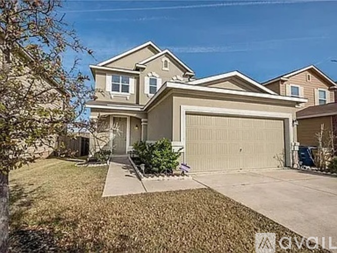 A two-story house with a garage is surrounded by a well-maintained lawn.