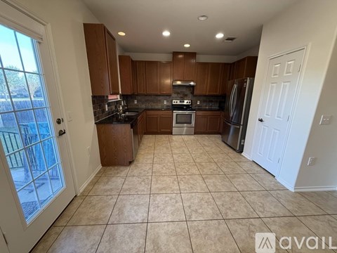 A kitchen with brown cabinets and a black countertop.