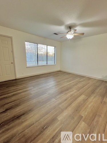 A room with wooden flooring and a ceiling fan.