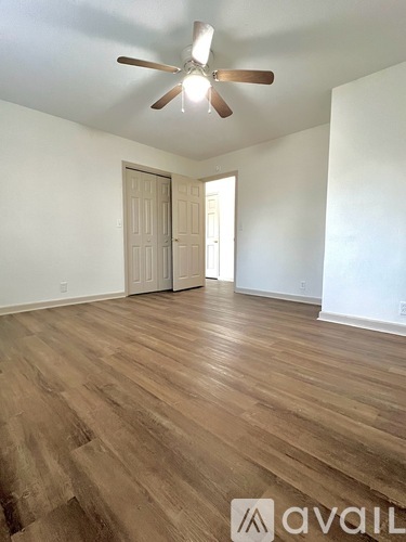 A room with wooden flooring and a ceiling fan.