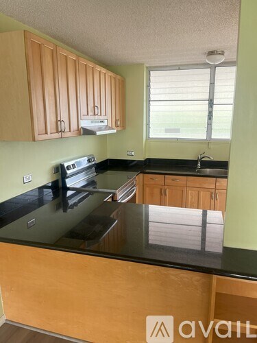 A kitchen with wooden cabinets and black countertops.