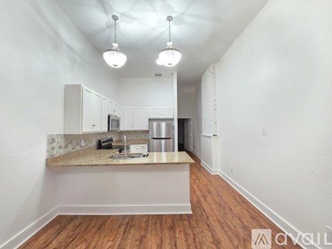 A kitchen with white cabinets and a granite countertop.