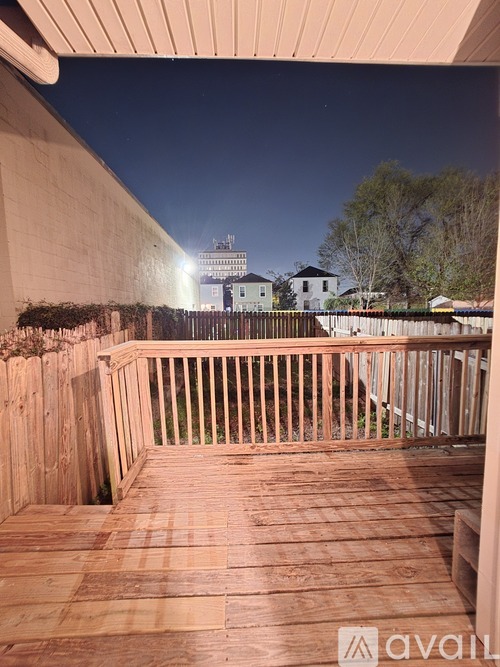 A wooden deck with a view of a building in the distance.