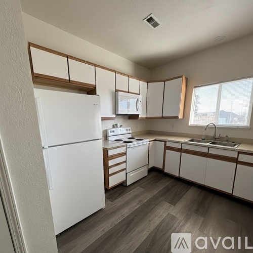 A kitchen with white appliances and wooden accents.