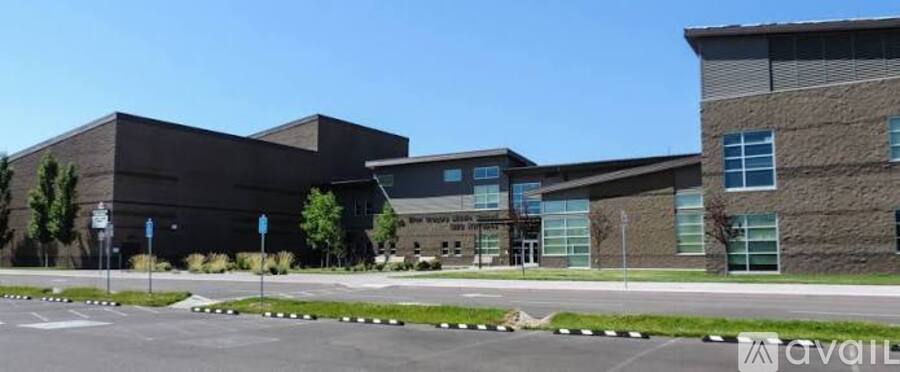 A modern building with a parking lot in front.