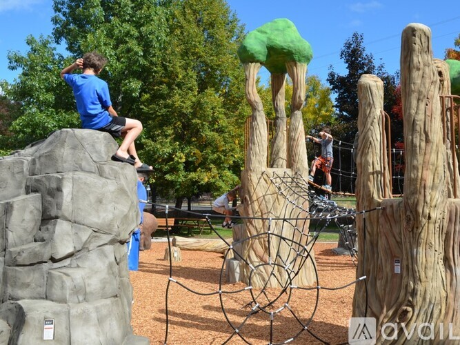 A child is climbing a tree-like structure at a playground.