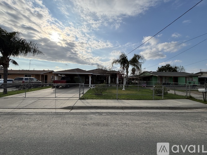 A sunny day in a residential area with houses and palm trees.