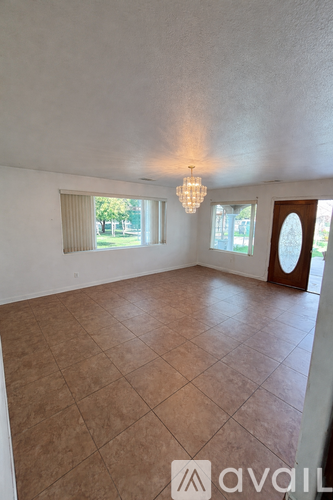 A room with tiled flooring and a chandelier hanging from the ceiling.