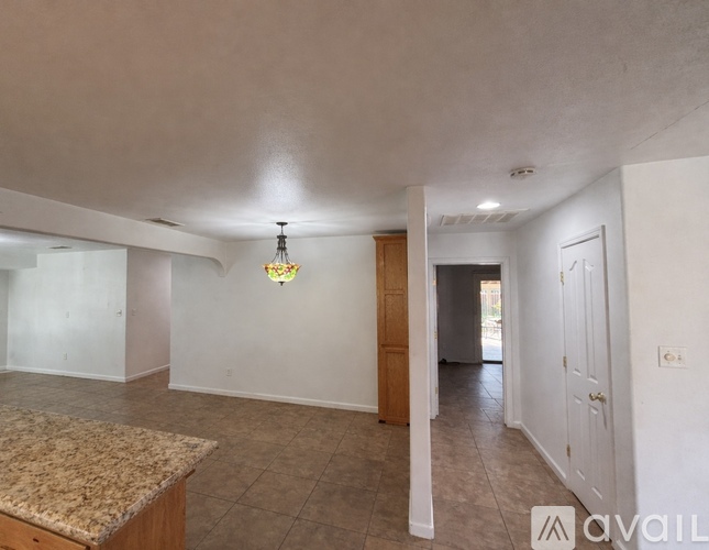 A room with a marble countertop and a hanging light fixture.
