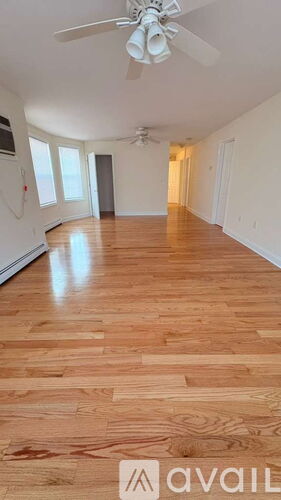A room with wooden flooring and a ceiling fan.