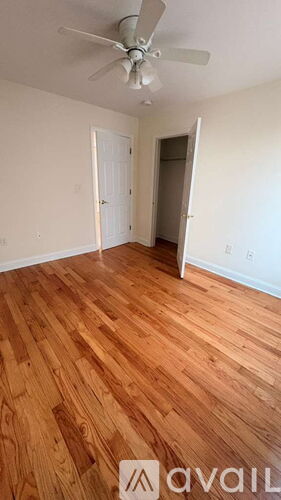 A room with a wooden floor and a ceiling fan.